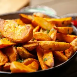 Chrupiące ziemniaki z airfryer, przyprawione ziołami, w misce. Idealny dodatek do obiadu, jak stek.