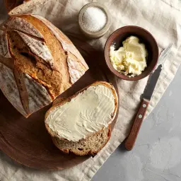 Chleb na drożdżach, świeżo upieczony, z masłem i solą. Idealny do przygotowania pysznych kanapek.